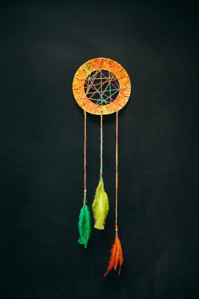 Pretty paper plate beaded dream catchers designed with yarn, beads, and feathers.
