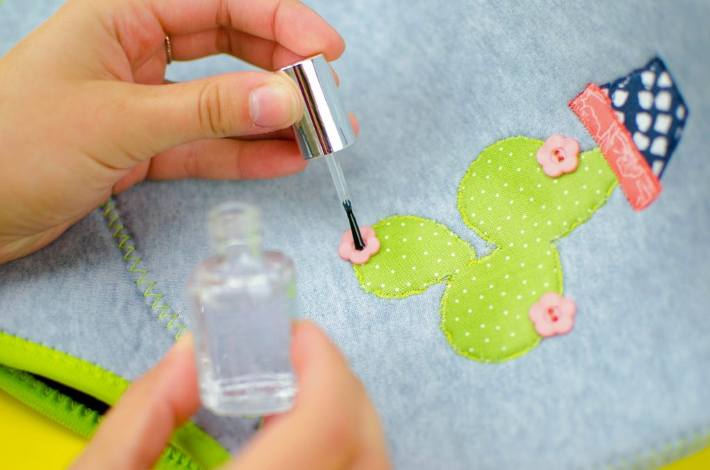 use clear nail polish to secure button threads