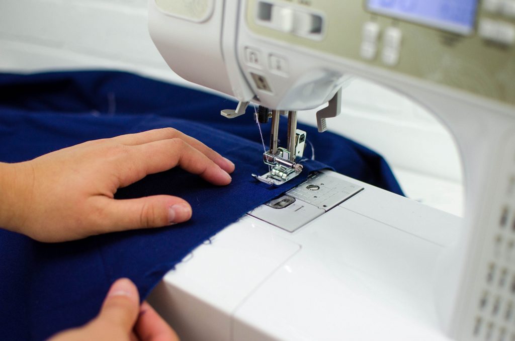 using a sewing machine to stitch a line 1/4 inch away from desired seam allowance for rolled hem