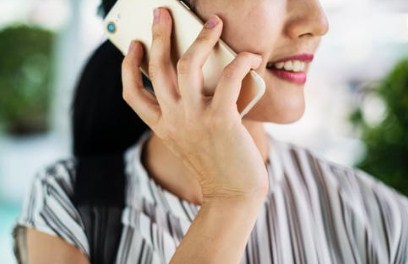 call the utility companies as soon as you know your moving date - image of a woman talking on a phone