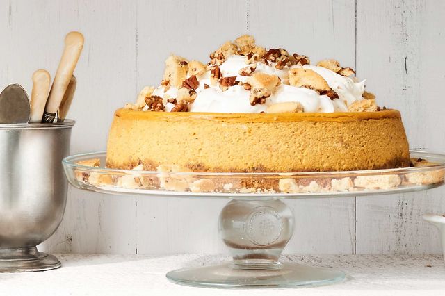 Pumpkin cheesecake with pecan cookie crust topped with whipped cream and garnish with cookies and pecans