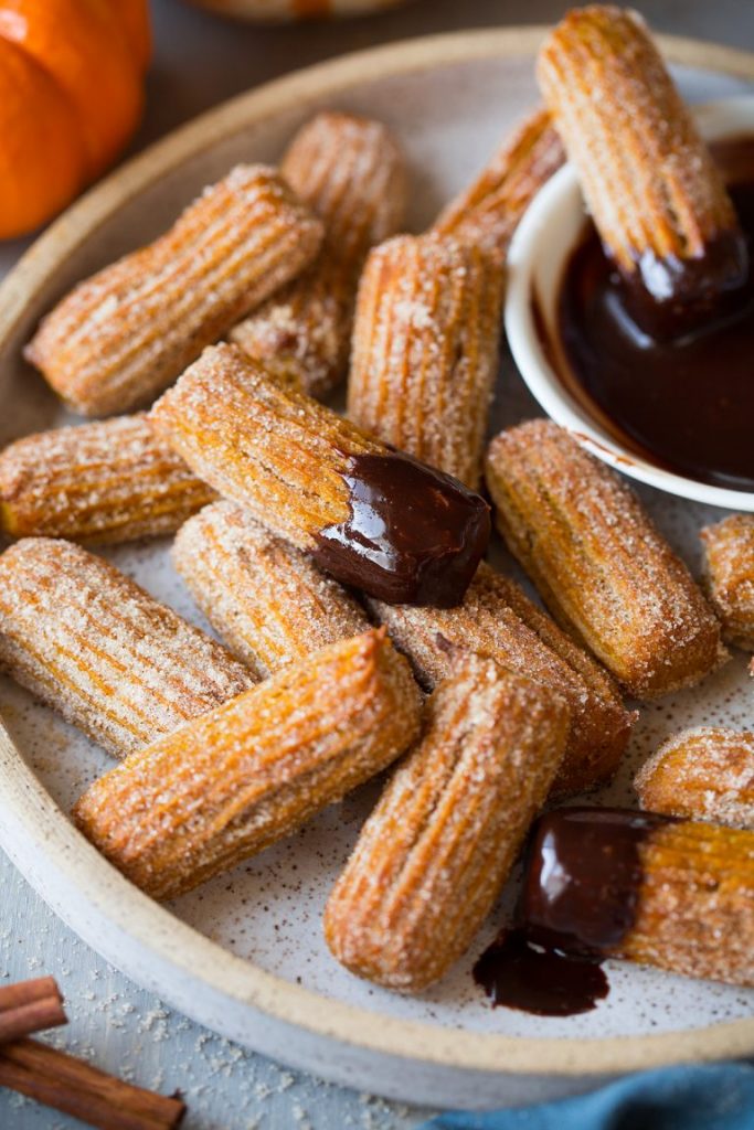 Baked pumpkin churros coated in cinnamon sugar with chocolate dip