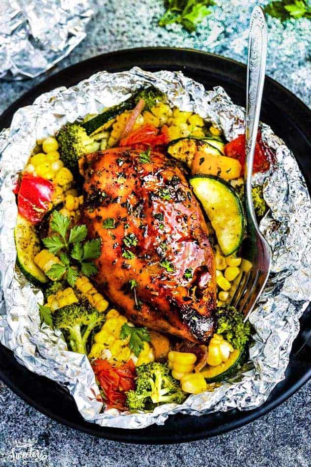 Perfectly tender chicken grilled with fresh summer veggies and coated in a delicious sweet and tangy barbecue sauce foil packets