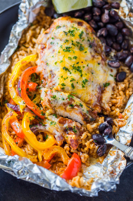 Flavor packed chicken, rice, bell pepper, onion and black beans all cooked in foil packets garnished with cilantro and sour-cream