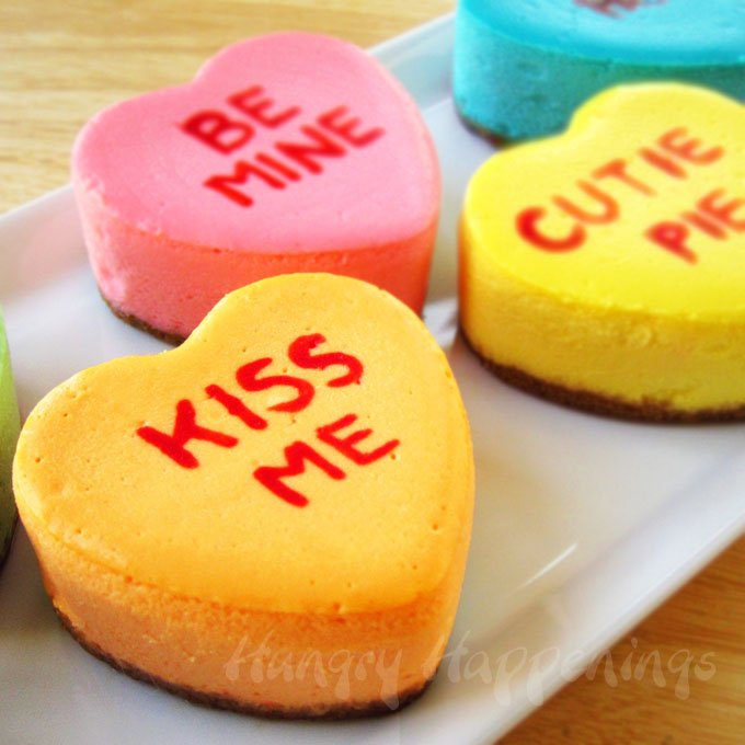 Personalized heart shaped cheesecakes, with messages printed on the top. It says be mine, kiss me, and cutie pie