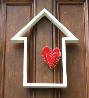 house shape door decor with a cut out hearts hang in the middle