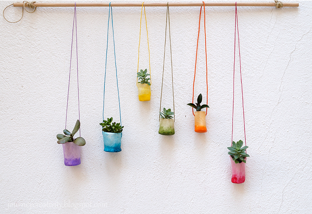 air dry clay plant pots painted in rainbow colors and hanging from a dowel