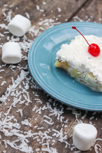 Tropical summer cake topped with whipped topping and coconut.