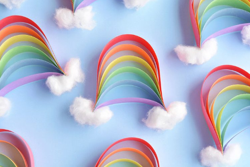 Paper strips rainbows with cotton balls on both end of the rainbow that looks like clouds