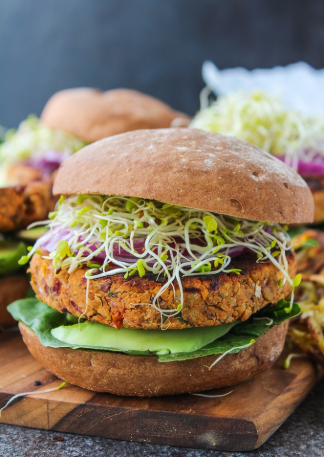Gluten free & vegan chickpea burger made with fresh basil, sun dried tomatoes, and ground almonds with red onion and sprouts