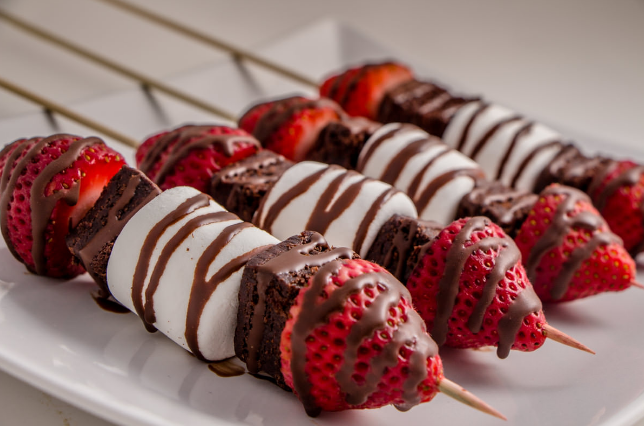 Strawberries, brownie bites and marshmallows on a stick