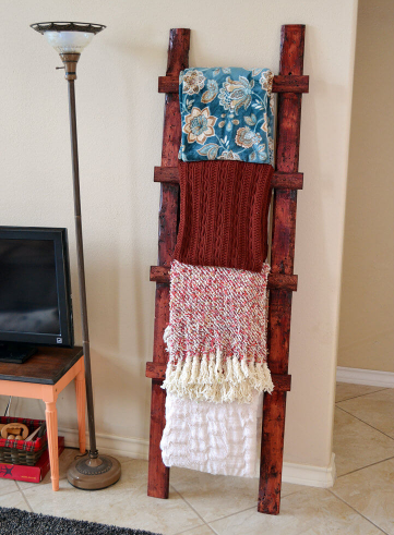 wooden ladder holding throw blankets