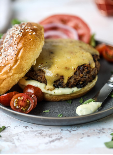Best veggie burger with garlic herb mayo and tomatoes on the side