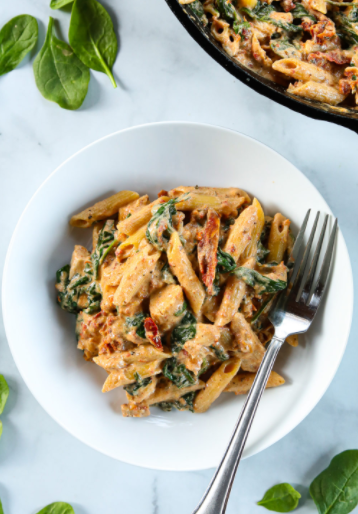 A plate of creamy tuscan chicken pasta