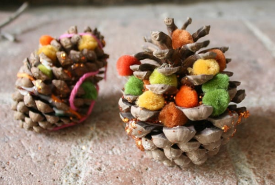 Pine cones decorated with pompoms and glitters