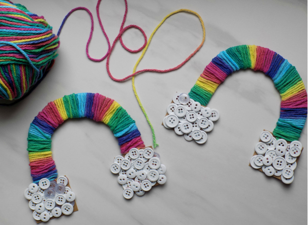 A gradient yarn rainbow with a handful of multi-size white buttons on each end
