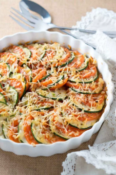 Light and delicious thinly sliced zucchini and tomatoes gratin topped  with shredded Parmesan cheese