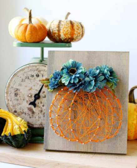 beautiful flowers added to a string art pumpkin