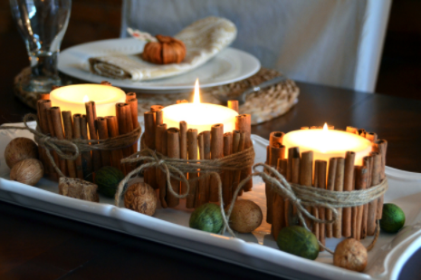Lighted candles wrapped with cinnamon sticks fall centerpiece