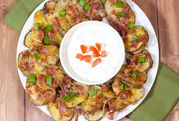 Irish nachos, it's basically Crispy, seasoned potato slices that are drowned in cheese, bacon, green onions and cilantro. with sour cream mixed and diced tomatoes dip