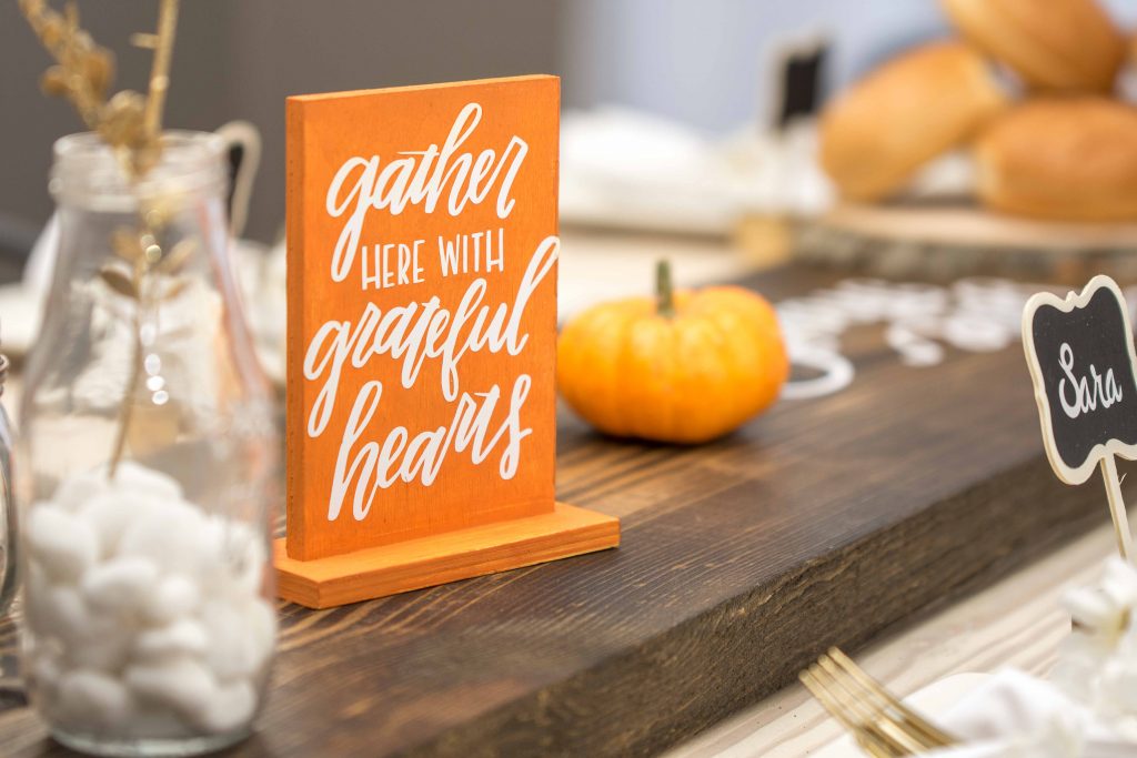 Sign centerpiece with text saying gather here with grateful hearts