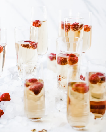 A fancy bubbly glass of mock champagne with raspberries