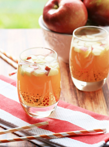 Apple pie punch on a glass with fresh sliced apples on top