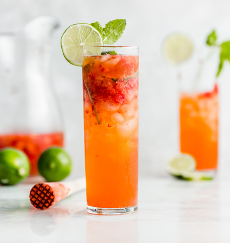 Strawberry lime mojito mocktail on a glass with sliced lime and mint leaves on top