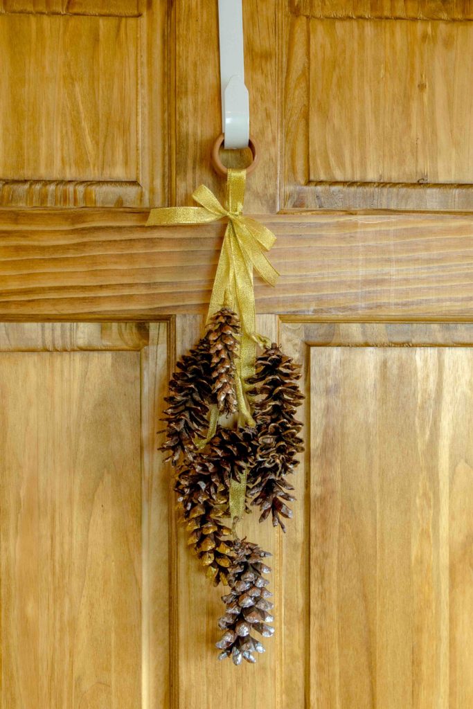 A pine cone wreath door hanging