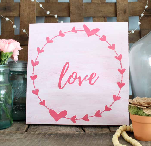 farmhouse style wooden sign with a circle of hearts and the word love in the center of the circle