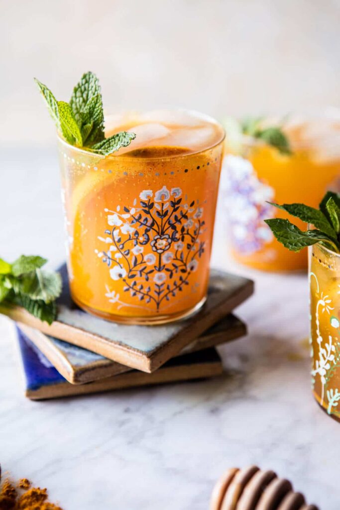 golden glow water in a glass with citrus slices and fresh mint.