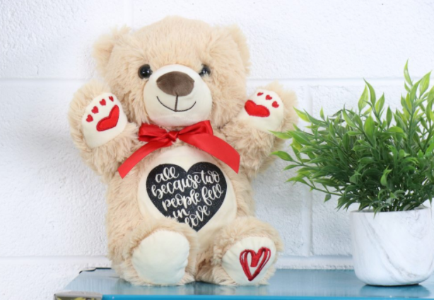 teddy bear with heart on his belly saying All because two people fell in love