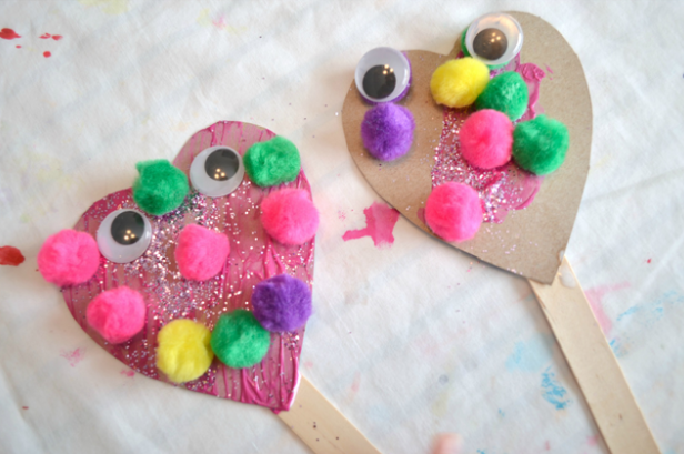 Silly heart puppet with some colorful puffballs on it.