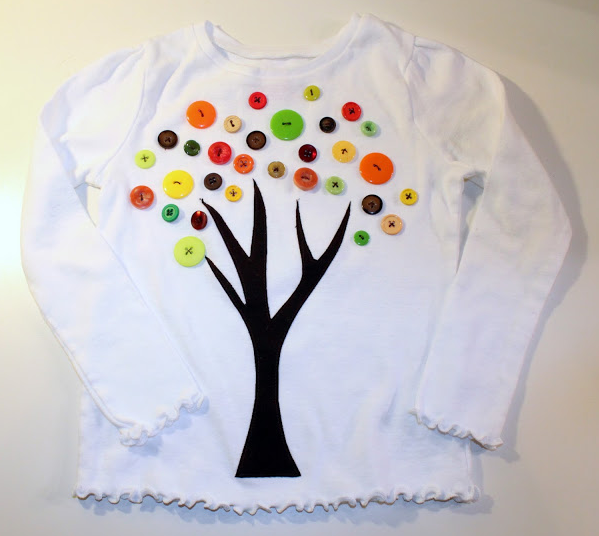 tshirt with a tree trunk painted on and 100 buttons as leaves