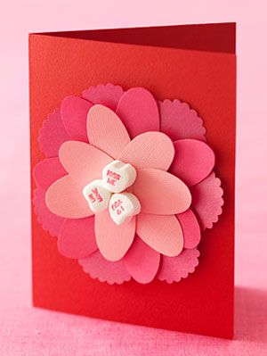 Valentine's day card with flower petals and candy hearts on the middle