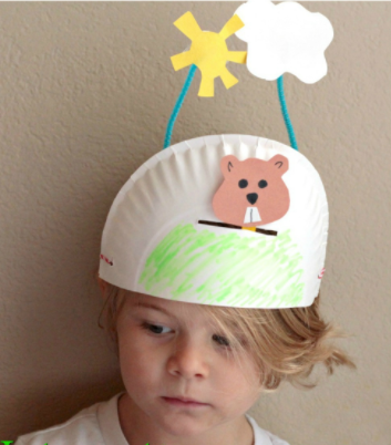 half a paper plate crown with paper groundhog and paper sun and cloud sticking up from it