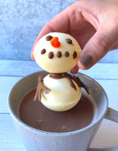 Hot cocoa bomb that looks like a melting snowman in the mug