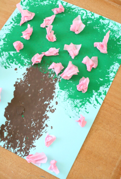 A spring painted tree with a pink DIY flowers made from a crumble pink tissue paper