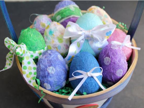 Plastic Easter egg covered with assorted colors of tissue paper with glitters and ribbon.