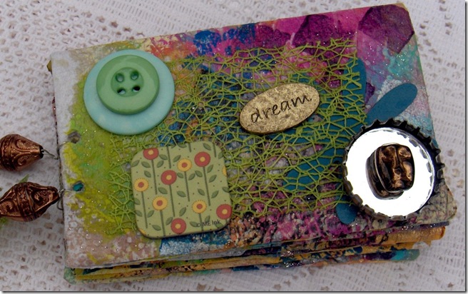 Cute mini scrapbook made from toilet paper that has some embellishments