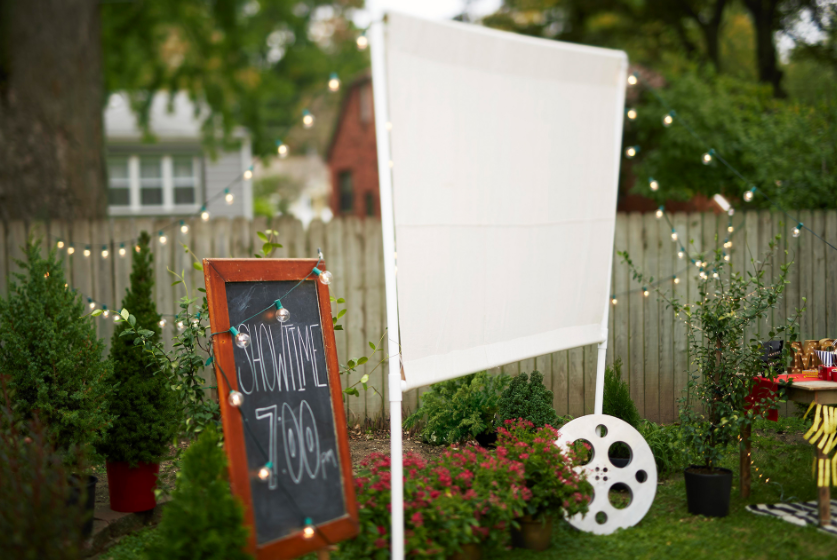 A homemade outdoor movie screen made of pvc pipes and drop cloth for backyard theater