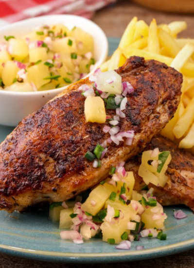 Grilled cajun chicken with fruit salsa and fries on the side