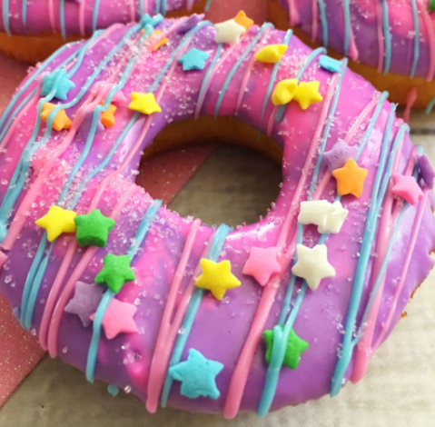 Unicorn cake donuts drizzled with pink and blue melted chocolate and sprinkled with stars and pink sugar