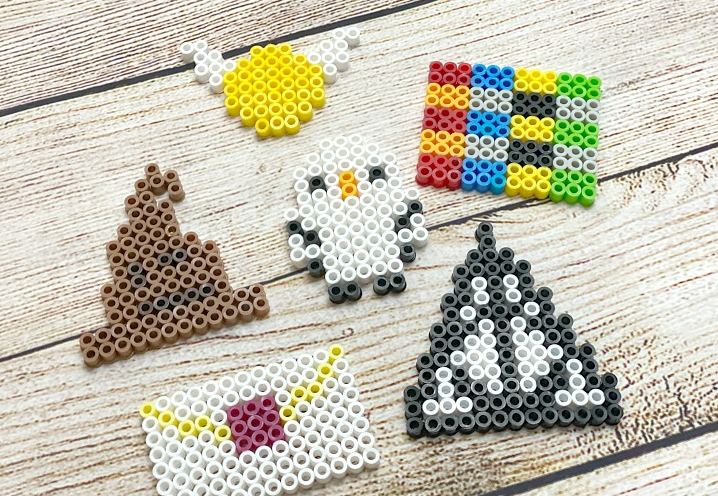 Harry Potter themed perler beads. The designs are Deathly Hallows, a Sorting Hat, a Golden Snitch, an Owl, a Hogwarts Letter, and House Colors.