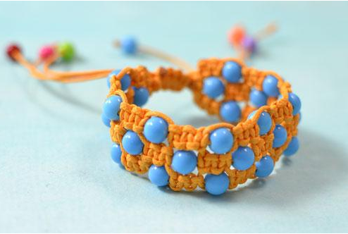A cute orange square knot friendship bracelet with blue acrylic beads 