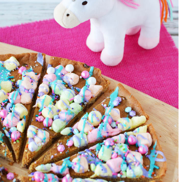 chocolate chip cookie decorated to looks like a unicorn pizza