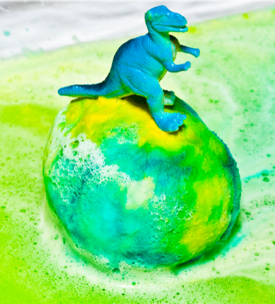 A dinosaur on top of a dinosaur egg covered with colored baking soda
