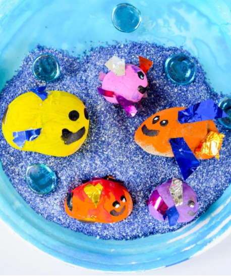 A colorful painted rock fish craft and play idea for kids this summer