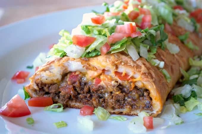 A taco made with ground beef cheese tomatoes wrapped in braided pizza dough
