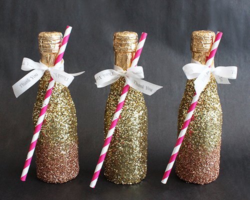 A fancy champagne bottle made with gold, glitter, and decorative straws
